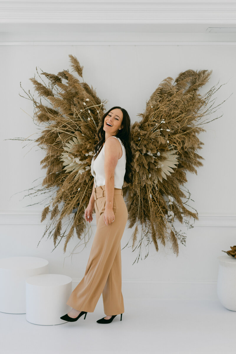 kat laughing in front of butterfly shaped wall decoration