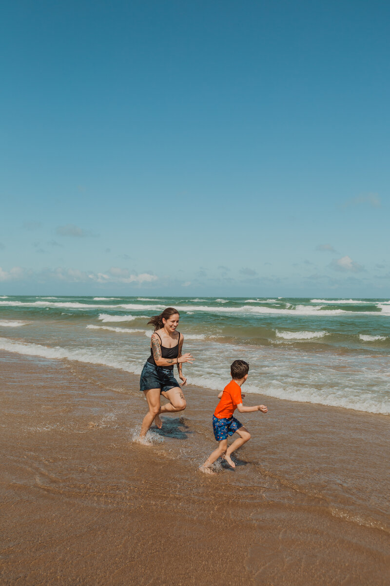 A mom plays with her son during a family photo session at South Padre Island