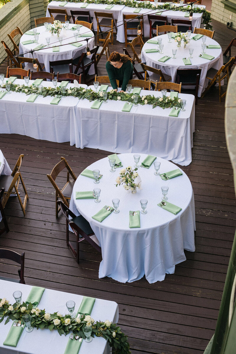 Outdoor wedding reception tables with greenery decor
