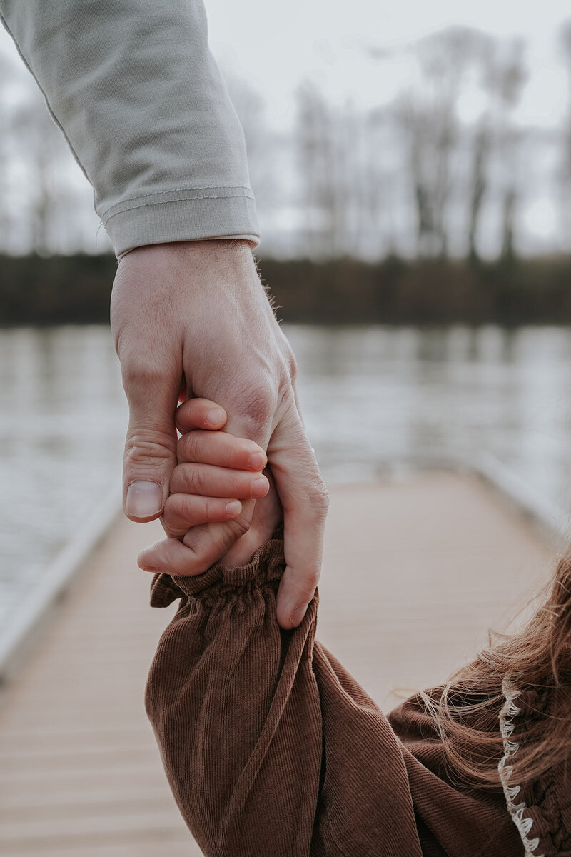 Family photos with a little one holding their hand. 