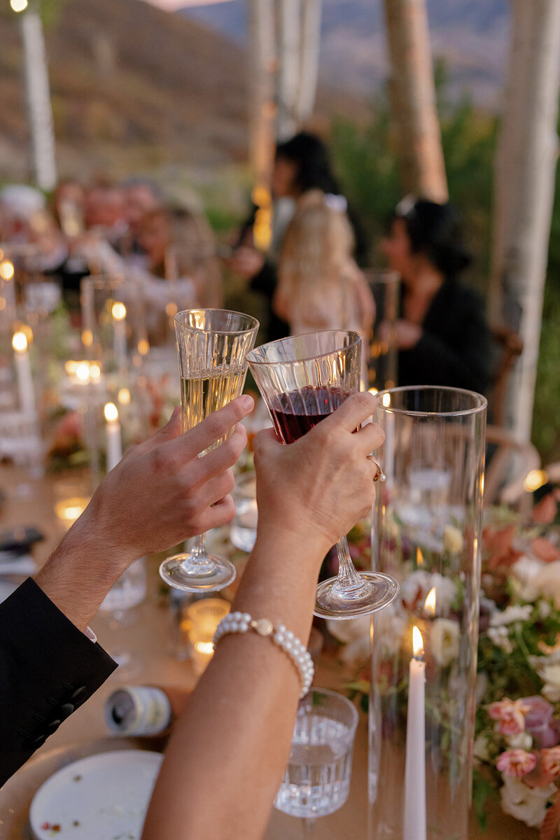 Image shows bride from the neck down, in a strapless wedding gown, holding her bouquet of blush and lavender roses.