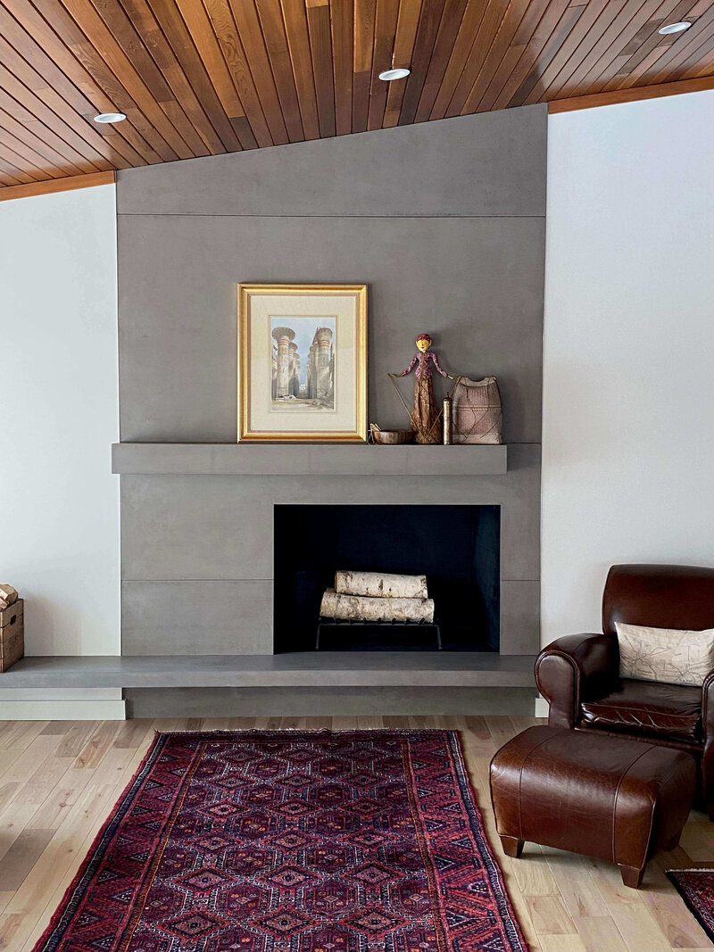 Modern concrete fireplace surround with floating mantel and hearth with offset lines and angled ceiling