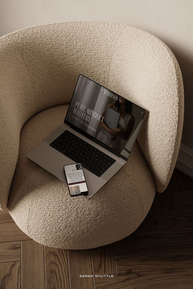 The Maddison Edit website shown on both laptop and phone screens resting on a chair, highlighting responsive luxury web design.