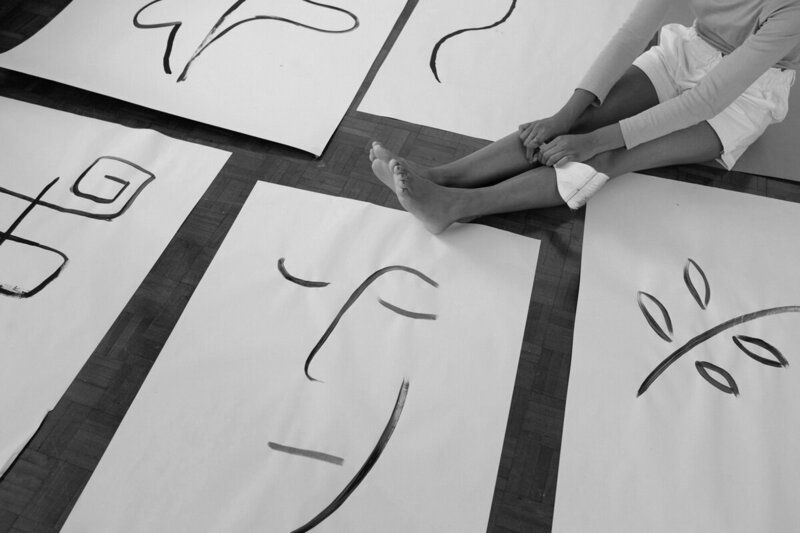 Creative individual sitting among abstract drawings, symbolizing the process of unblocking creative potential.