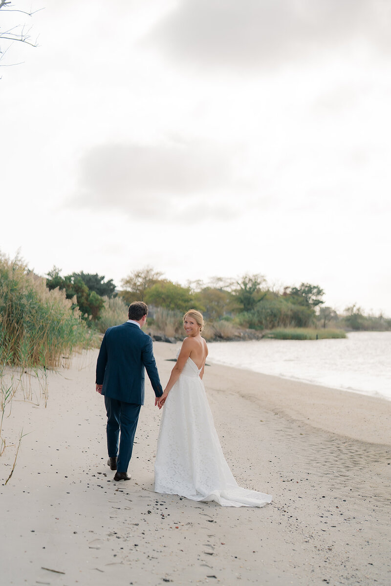 Bride and groom walking on the beach during portraits in Cape May, New Jersey