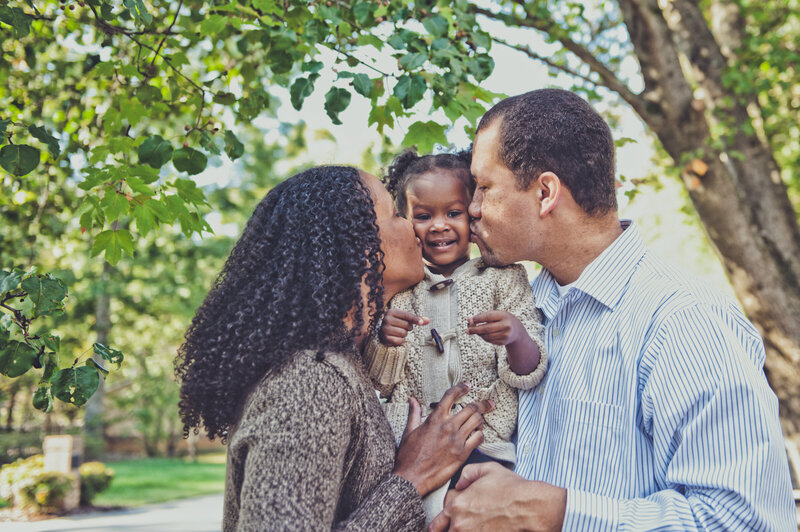 Photograph of family cuddling and being photographed by Tiona Fuller Family Photographer in Austin TX
