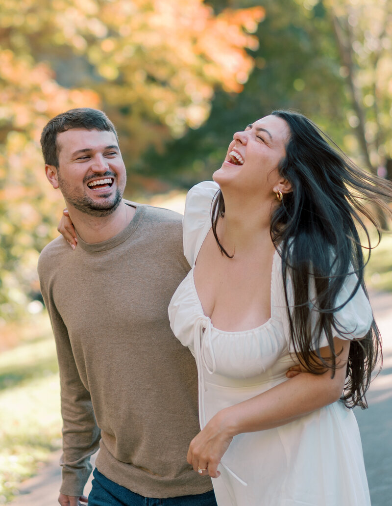 man and woman laugh while walking