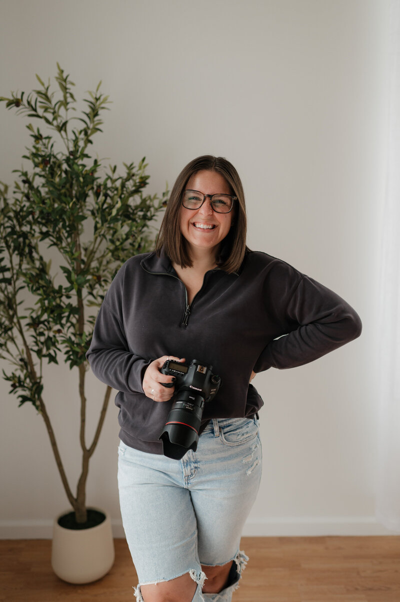 A photographer smiling while holding a camera 