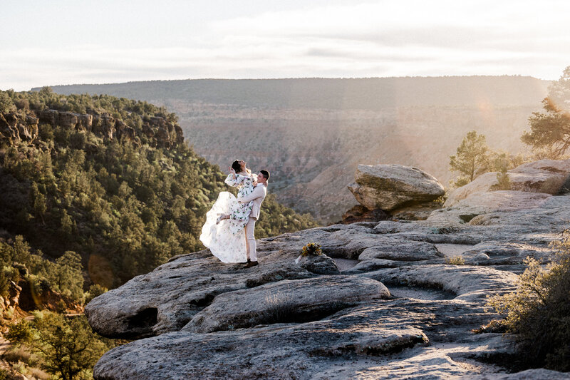 Couple walking down trail looking back holding lanterns