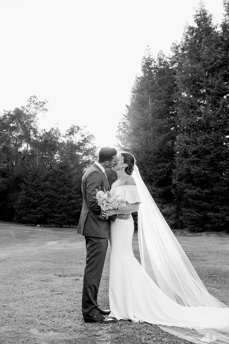 Bride and groom smile nose to nose on the beach on their wedding day