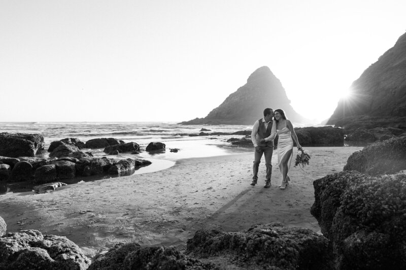 Bride and groom sitting on a bench in the Akron Art Museum with a gallery of paintings behind them. 