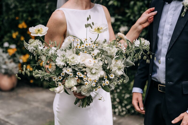 a details shot of a green white and yellow unstructured wedding bouquet by mrs bottomleys flowers