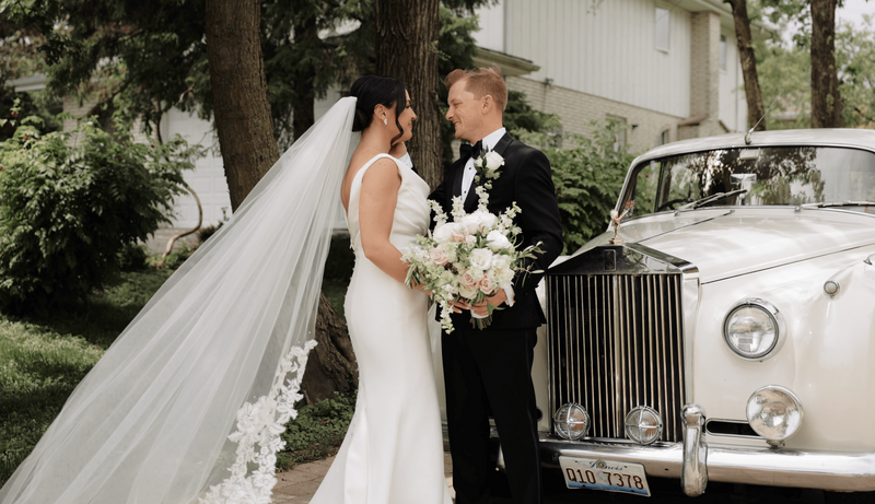 Bride and groom share a first look by a vintage car at Indiana wedding venue