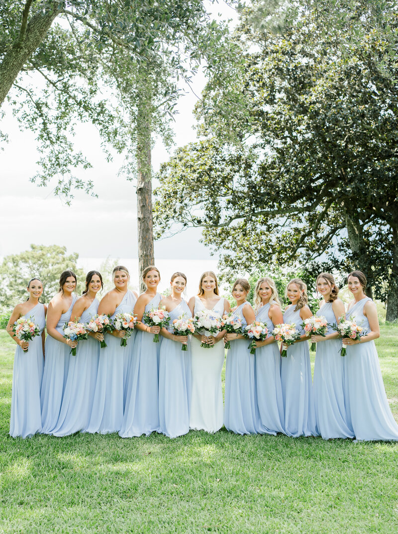 bride standing with bridesmaids in blue dresses