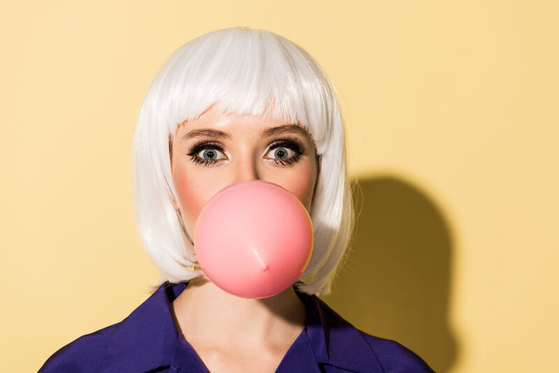 amazed-girl-in-white-wig-chewing-bubble-gum-on-yel-2022-01-28-08-53-55-utc