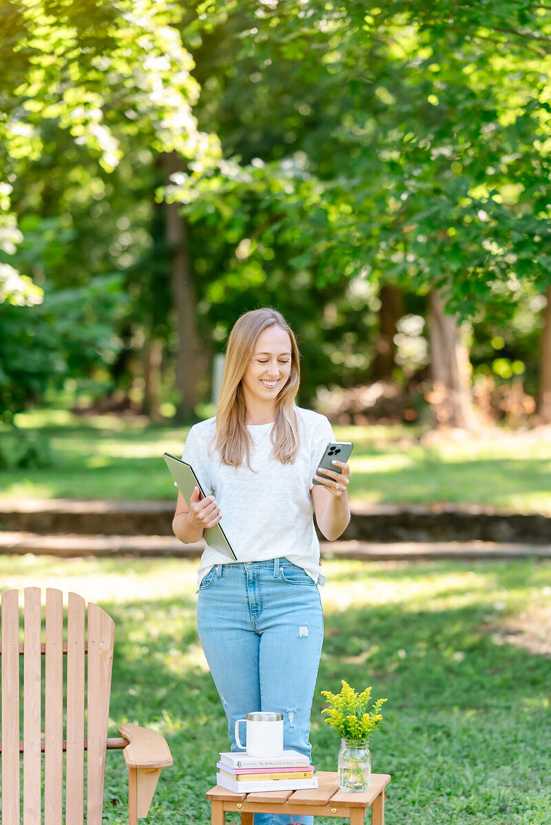 Virtual assistant looks at iPhone while carrying computer