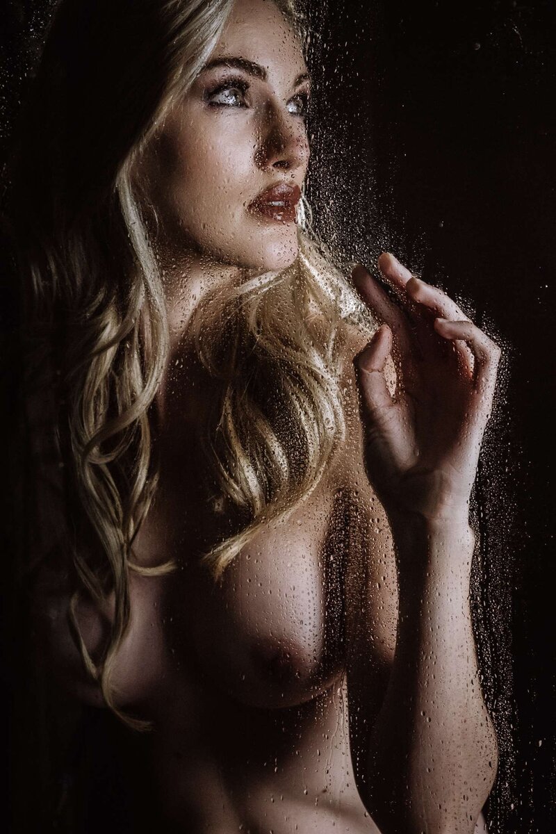 a women looks  up through a wet shower during a boudoir shoot in vancouver