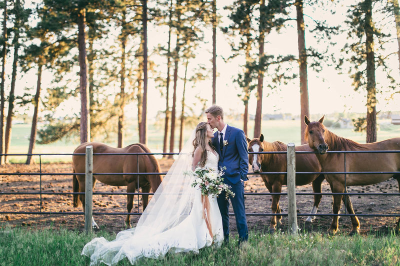 Destination Wedding in Whitefish Montana with horses in background behind a couple on their wedding day by Jennifer Mooney Weddings