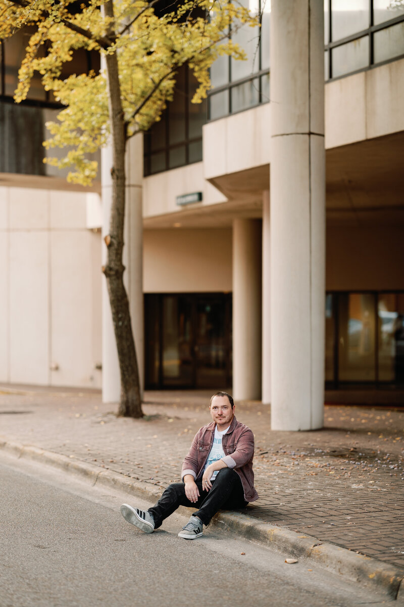 Owner of Vow and Vibe Wedding DJ sitting on a curb in Montgomery Alabama. 
