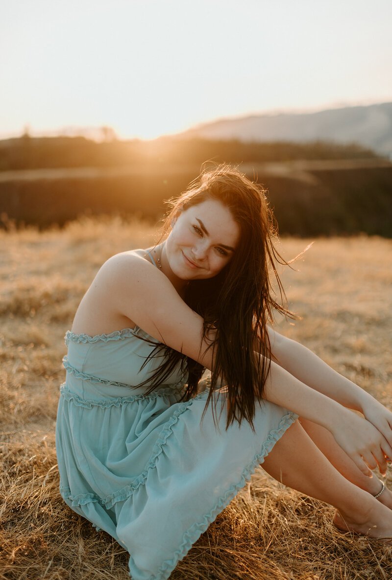 photo of Gaelflyne Swan, a senior in Oregon sitting in blue dress in grassy field