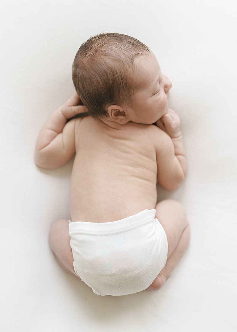 newborn baby boy photographed at home on a simple white backdrop