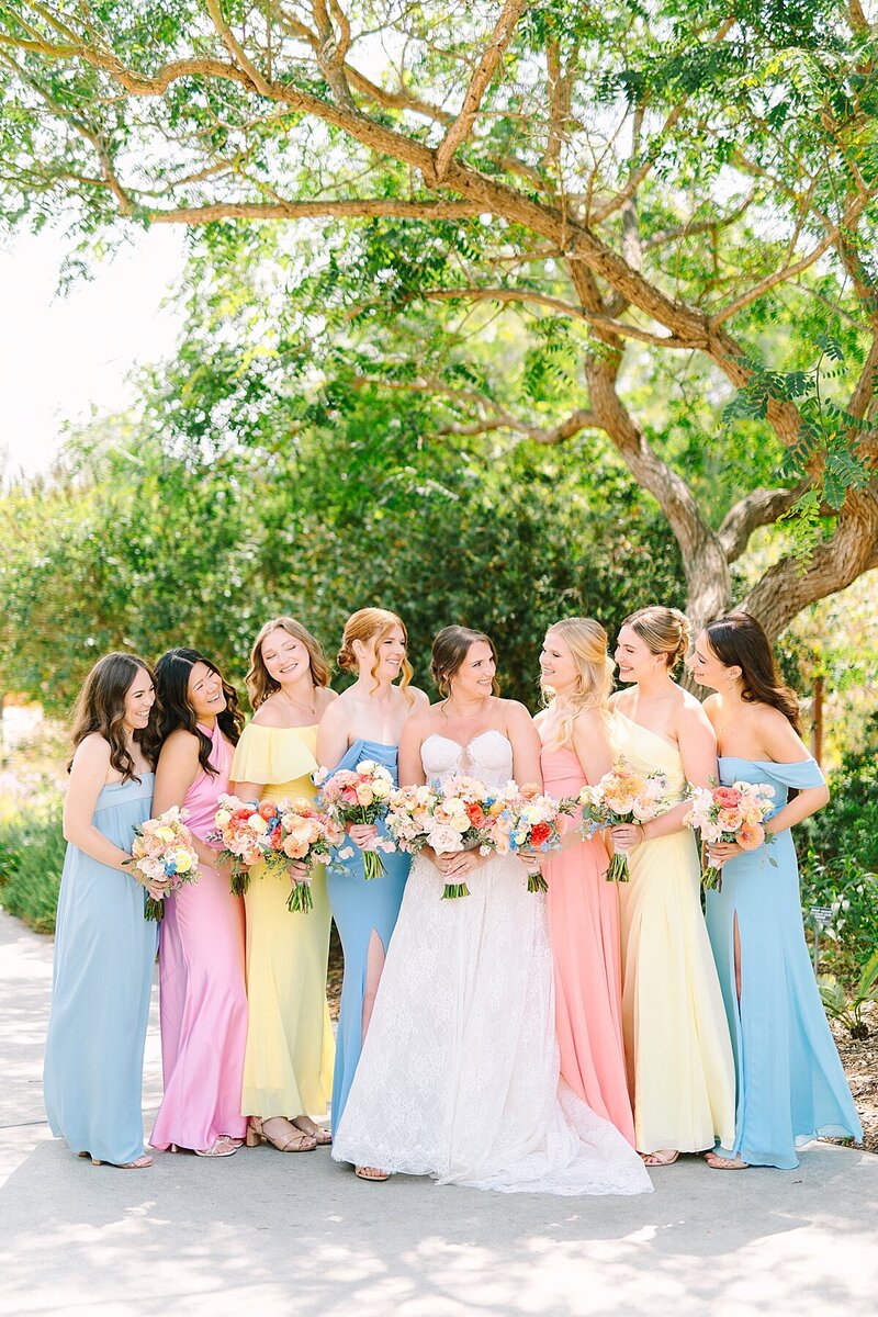 Bride and groom walking in front of boats on the harbor at Humphrey's Marina In San Diego, California.
