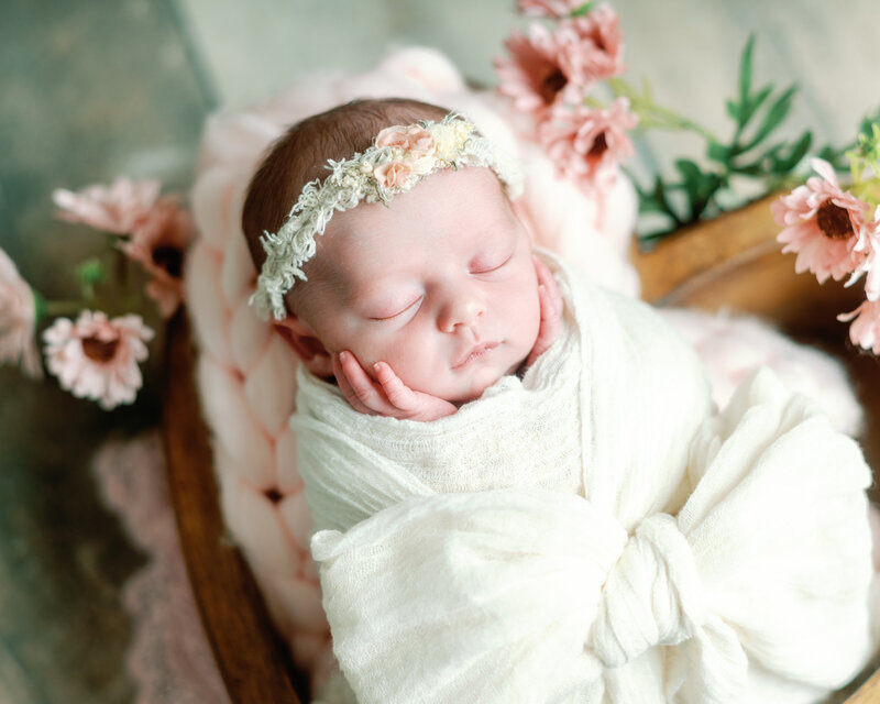 Bébé dort dans un panier, couleurs sombre, bois et vert, lumière flash