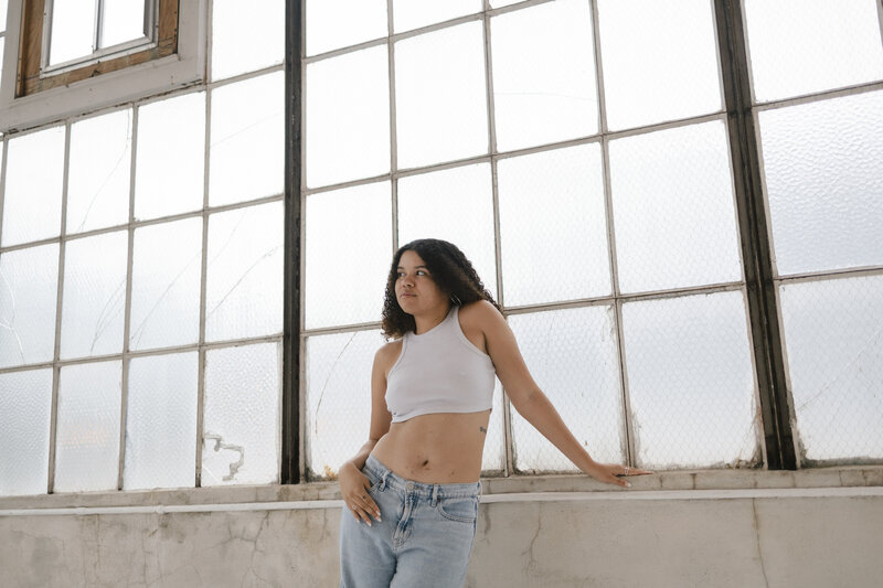 Photo of Catryce looking to her left with a window background