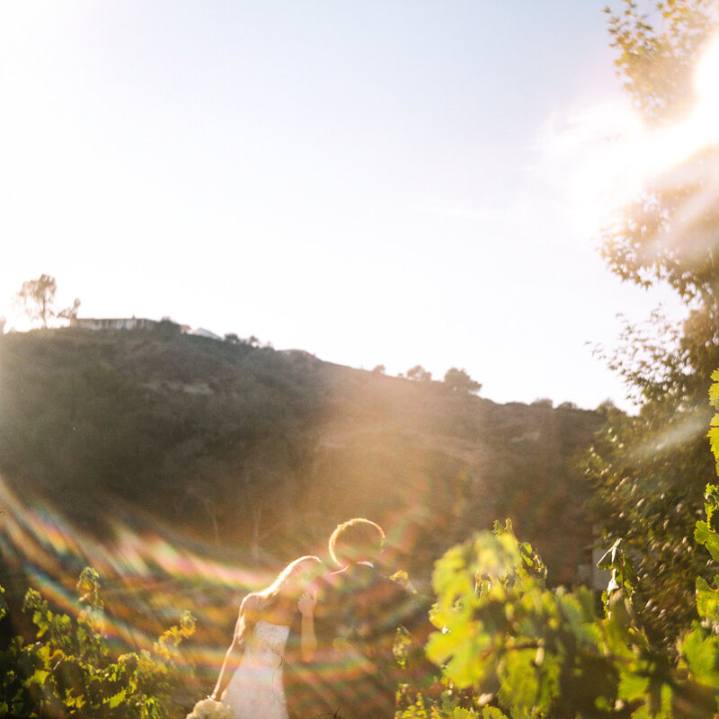 a film image of a couple embracing in california with some rainbow light leaks
