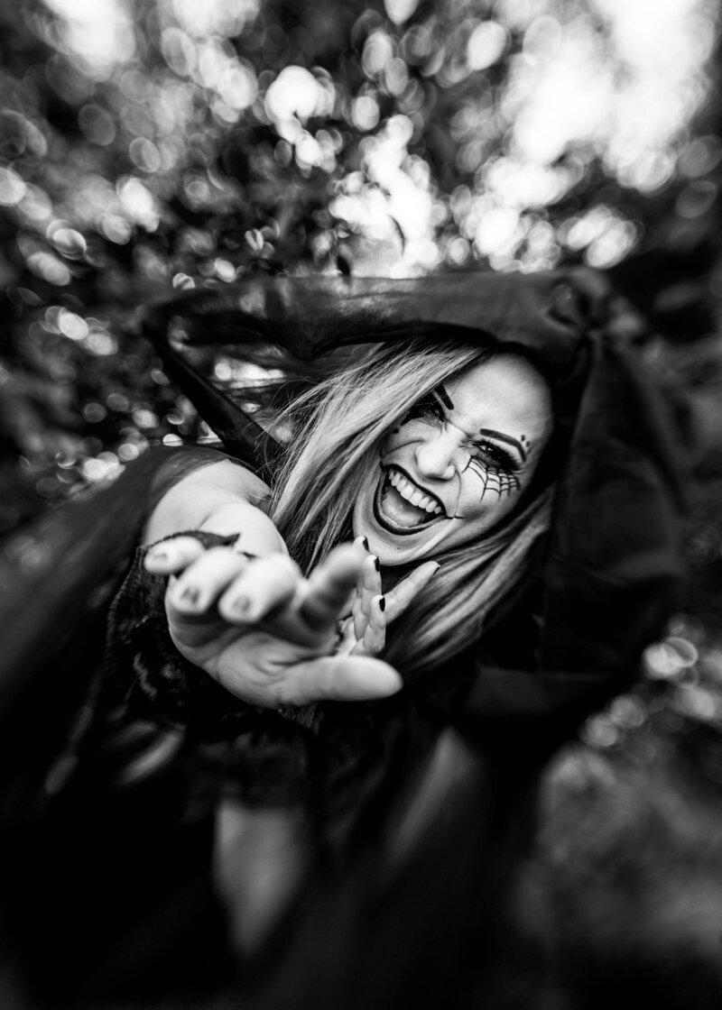 Black and white photo of a Halloween witch laughing and pointing