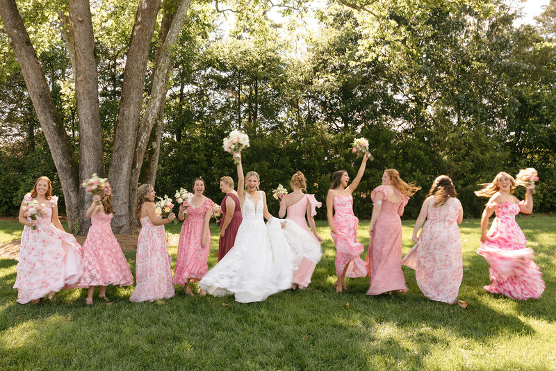 Bride and bridesmaids dancing in the grass at Nashville wedding
