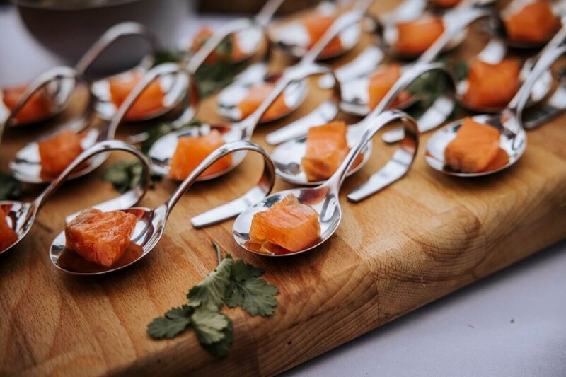 Beautiful canapes on a wooden block served on curly spoons