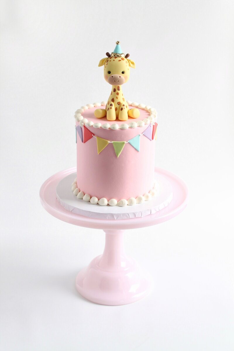 Pink cake with frosting and gold butterflies