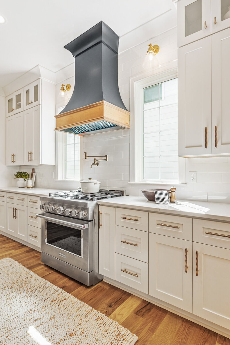 black range hood with white cabinets and gold fixtures