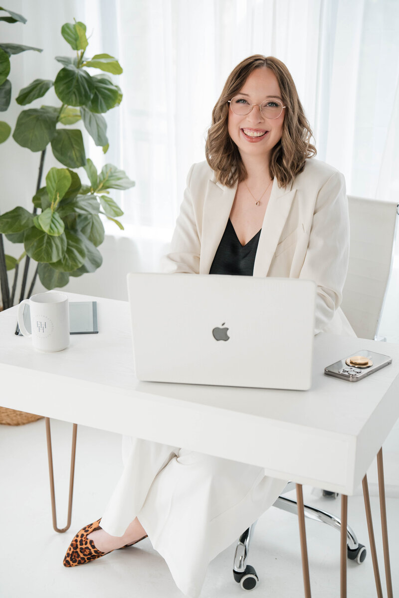 ashe sitting at desk with laptop
