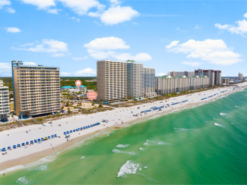 Aerial view of Panama City Beach with turquoise waters and rows of umbrellas, just a short stroll from the Orange Door townhouse and close to Santa Rosa Beach and Destin.