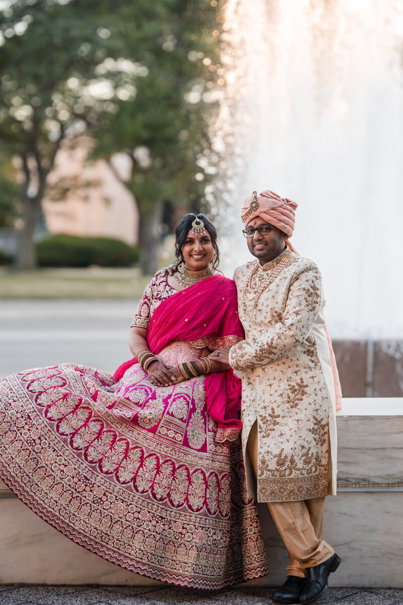 Indian Bride and Groom sitting in front of beautiful fountain on the steps of the Detroit Institute of Art.