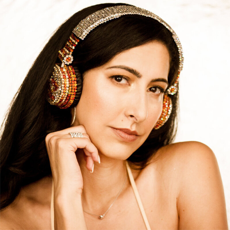 Personal Branding headshot female wearing jeweled headphones against white backdrop chin resting on hand