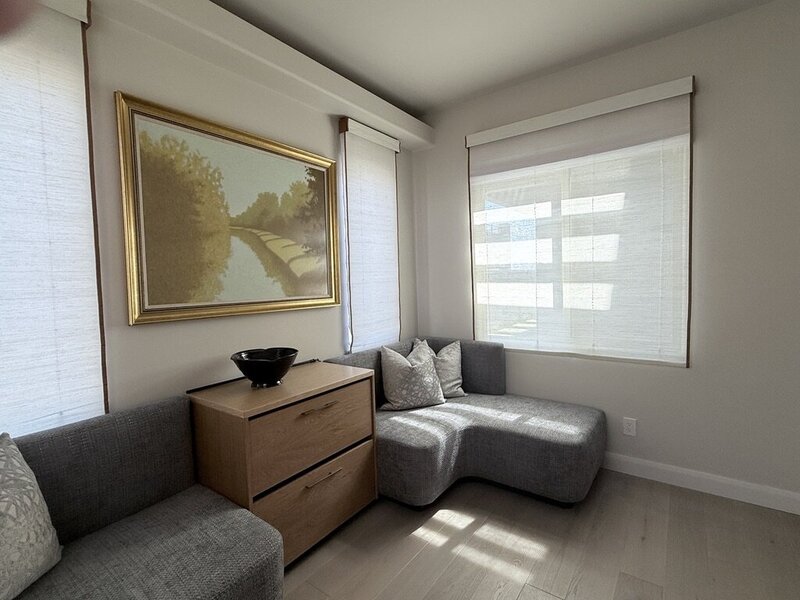 https://static.showit.co/800/M5IGD-X_EPHyTlYPofi_LA/328627/woven-wood-shades-sitting-room-corner-las-vegas.jpgWoven wood shades with soft banded edges on corner windows in a sitting room with gold-framed art