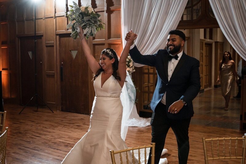 Bride and groom making their joyful grand entrance at Union Club Hotel wedding reception.