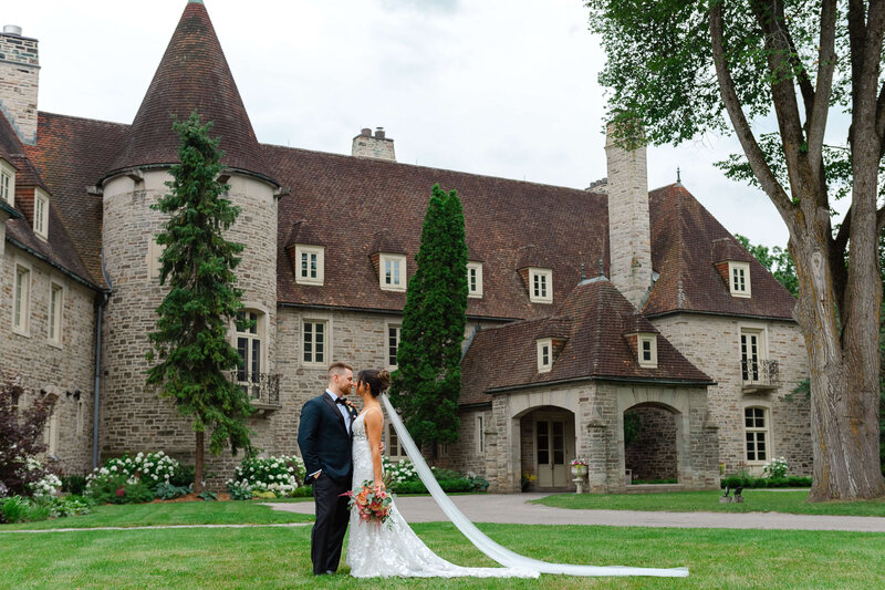 Ottawa wedding photos showing a bride and groom kiss with Eaton Hall in the background