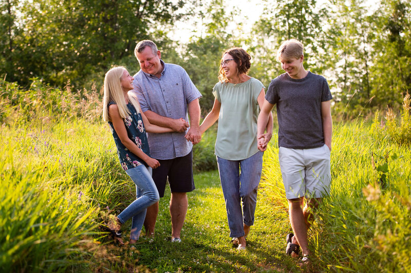 mom, dad, son and daughter walking and laughing during family photos