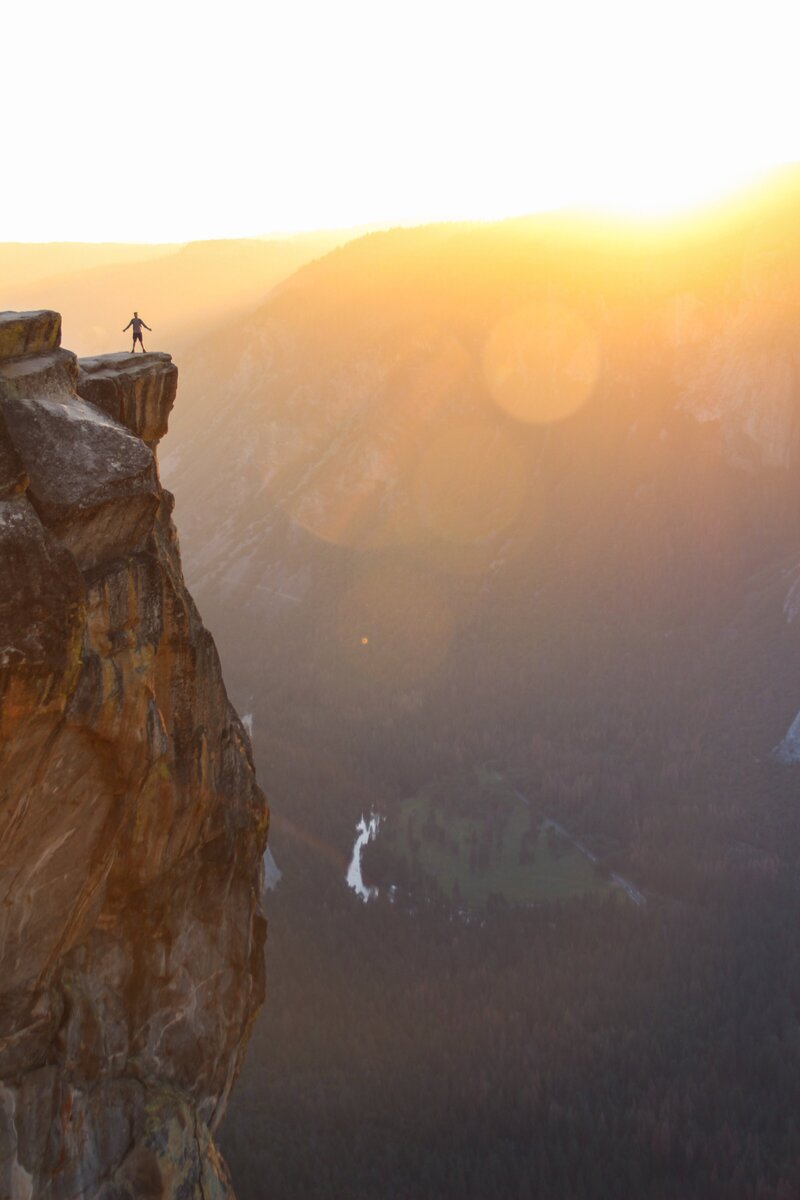 Sunrise scene with person standing on the edge of a cliff - Leo and Vern