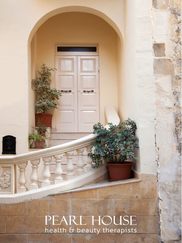 Front door landing with artistic railing and green plant pots with logo | Brand By Design