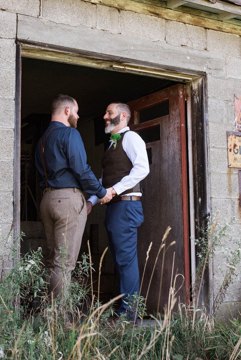 Two grooms smiling and looking at each other