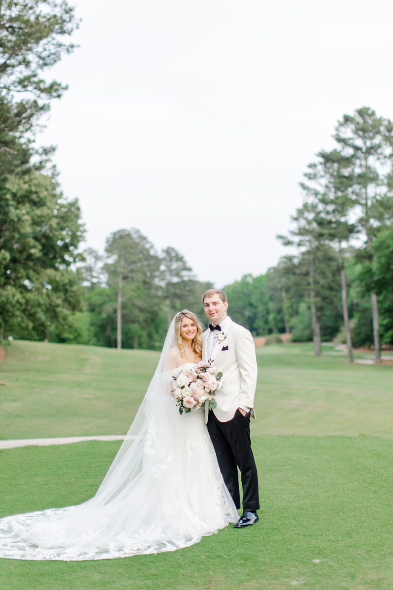 Bride and groom picture on a golf course in Atlanta, with the groom in a white tuxedo