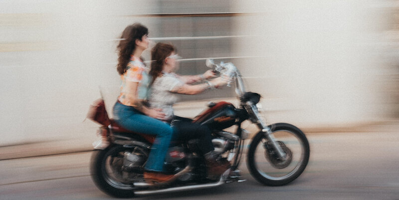 Blurred images of a couple on a motorcycle.