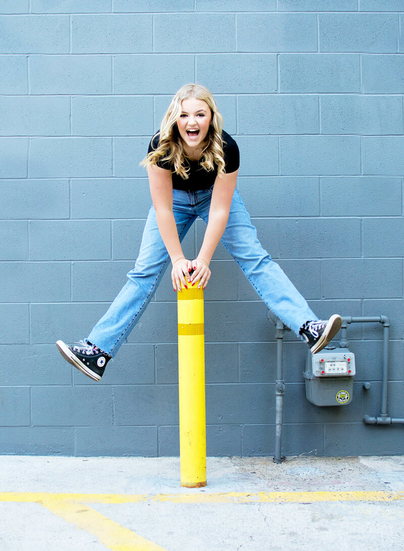 Tween jumping over a yellow pole in downtown Redlands  CA