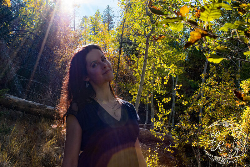 headshot of Lela in a grove of aspen trees under golden light