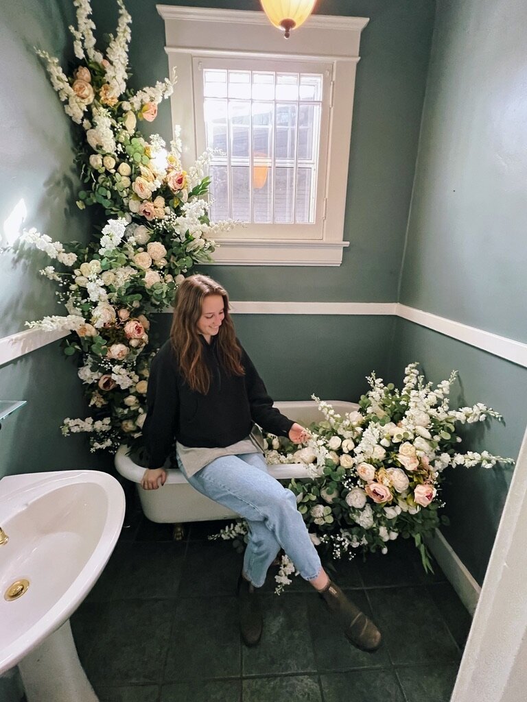Mackenzie LePage, Rosemary and Finch floral design associate floral designer, wedding and event floral design in Nashville, TN and travel weddings, florist. Wedding venue bathtub silk floral installation in colors of cream, pink, peach, white, sage, and natural greenery.